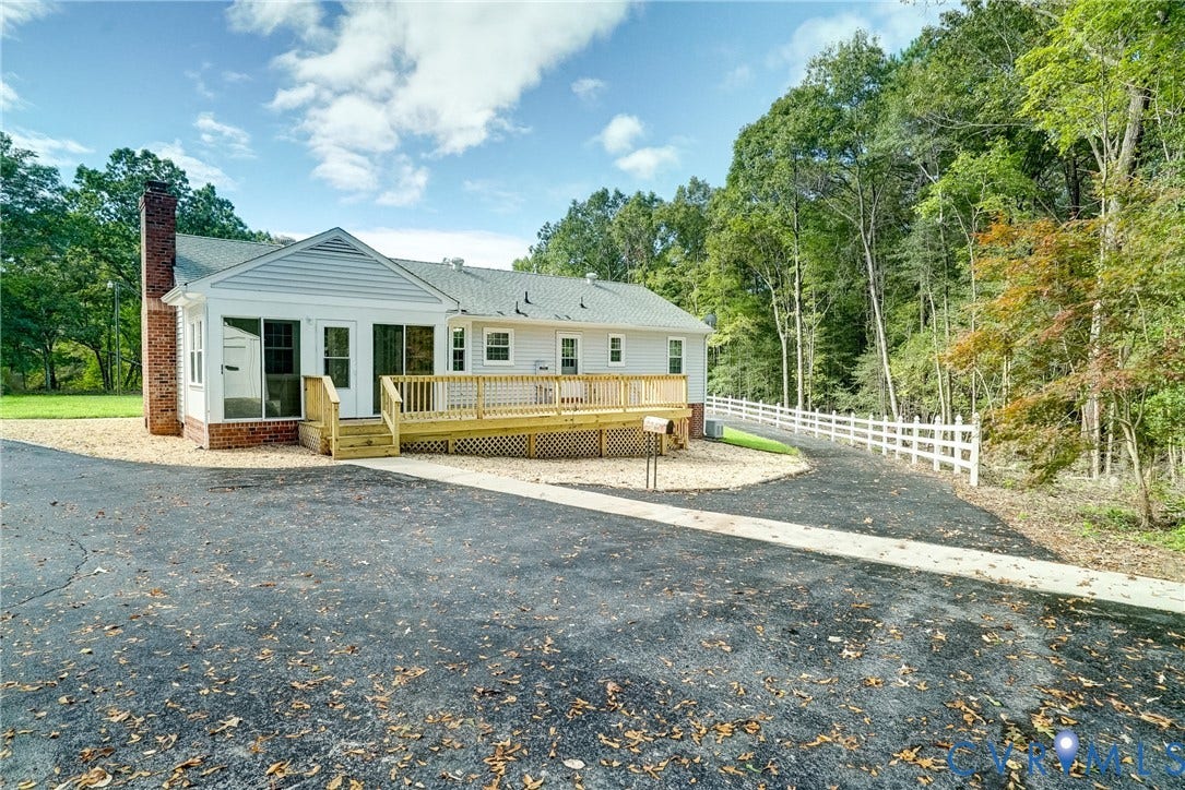 4130 Charles City Road, Charles City, VA 23231 Exterior featuring horizontal siding, a raised wooden deck with railings, a brick chimney, and an asphalt driveway