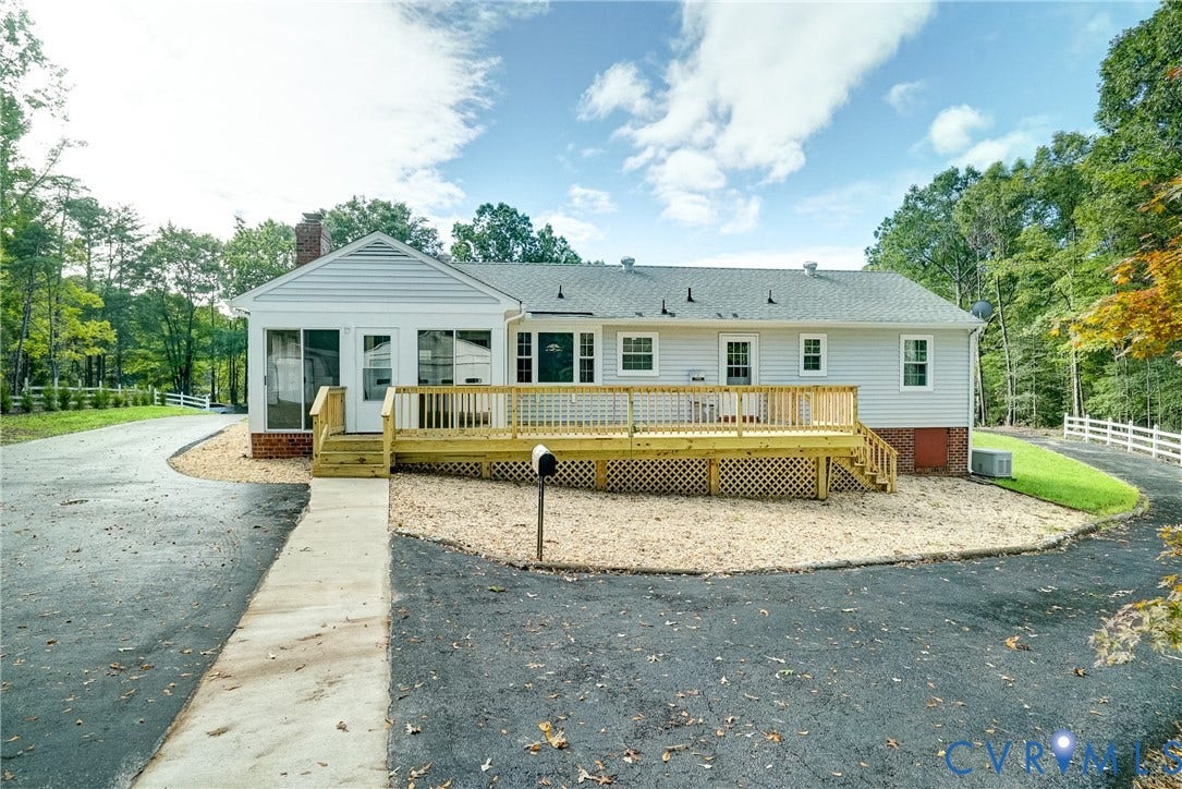 4130 Charles City Road, Charles City, VA 23231 Exterior featuring light-toned horizontal siding, a raised wood deck with latticework skirting, an asphalt driveway, and multi-paned windows