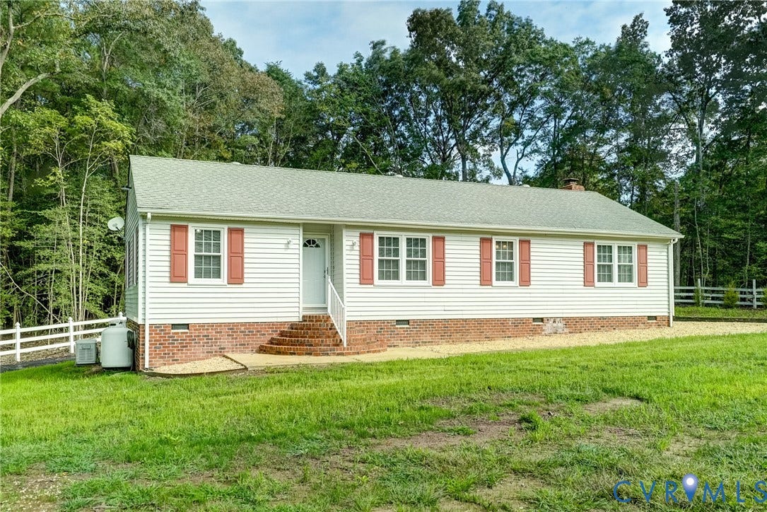4130 Charles City Road, Charles City, VA 23231 Single-story residence featuring vinyl siding, brick foundation skirting, multi-pane windows with decorative shutters, and a front brick stoop