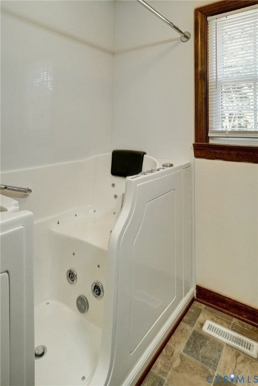 4130 Charles City Road, Charles City, VA 23231 Walk-in bathtub featuring a jetted hydrotherapy system, integrated seat, stainless steel grab bar, and high-gloss white surround