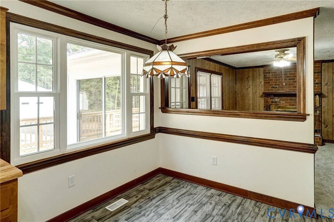 4130 Charles City Road, Charles City, VA 23231 Multi-pane windows, wood-finish flooring, stained wood crown and chair rail molding, stained wood-trimmed interior window, and stained glass-style pendant light fixture