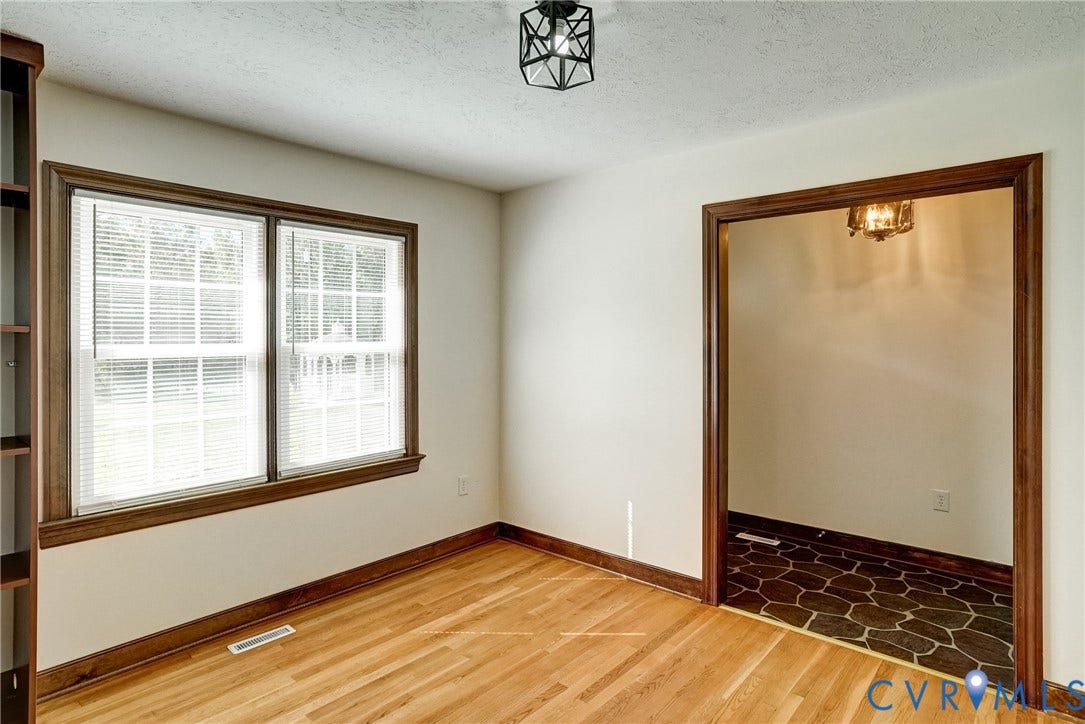 4130 Charles City Road, Charles City, VA 23231 Room featuring wood-finish flooring, dark wood trim, built-in shelving, a geometric semi-flush mount light fixture, and tile flooring with a stone-pattern finish