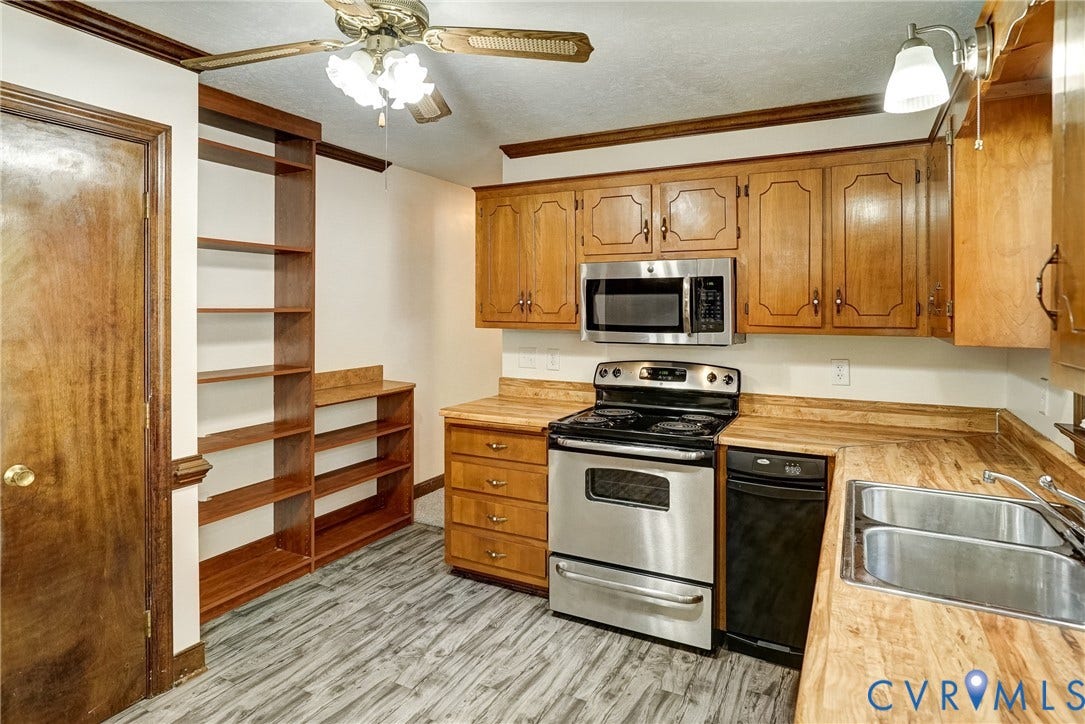 4130 Charles City Road, Charles City, VA 23231 Kitchen featuring wood cabinetry, built-in shelving, stainless steel appliances, countertops with wood-grain finish, and wood-finish flooring