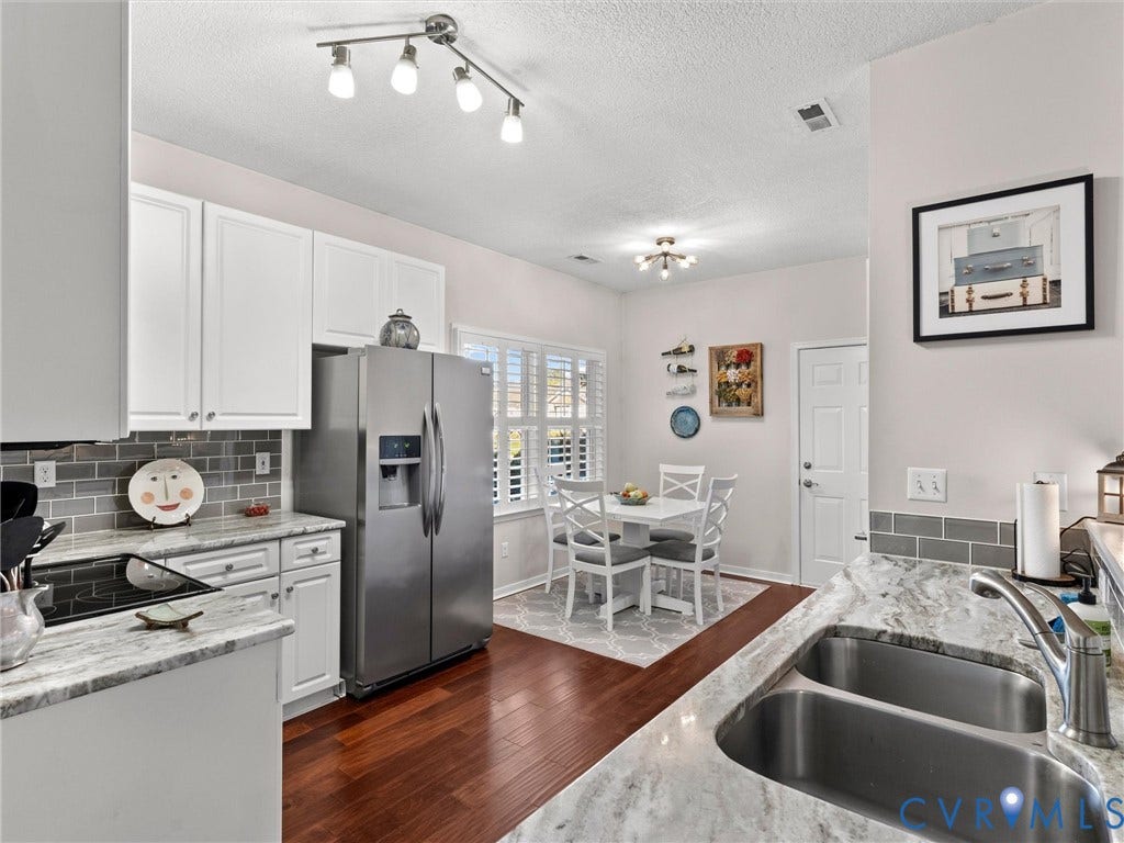 4105 English Holly Circle, Glen Allen, VA 23294 Kitchen featuring white cabinetry, stone-finish countertops, gray subway tile backsplash, dual-basin stainless steel sink, and wood-finish flooring