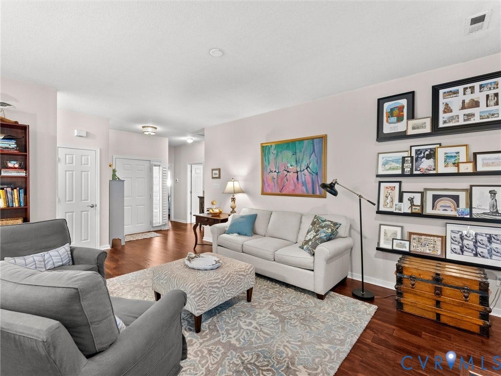 4105 English Holly Circle, Glen Allen, VA 23294 Living area featuring wood-finish flooring, high-contrast wall shelving, and a paneled entry door