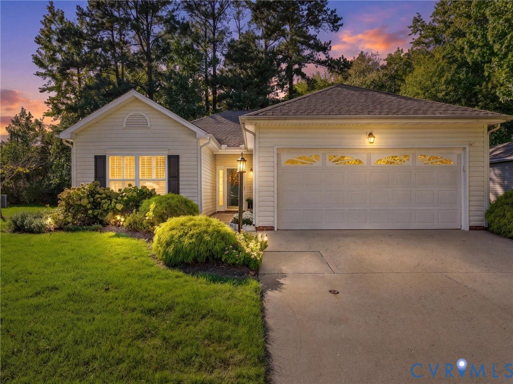 4105 English Holly Circle, Glen Allen, VA 23294 Single-story residence featuring light-colored horizontal siding, a multi-gabled roofline, an attached two-car garage with glass inserts, and a concrete driveway