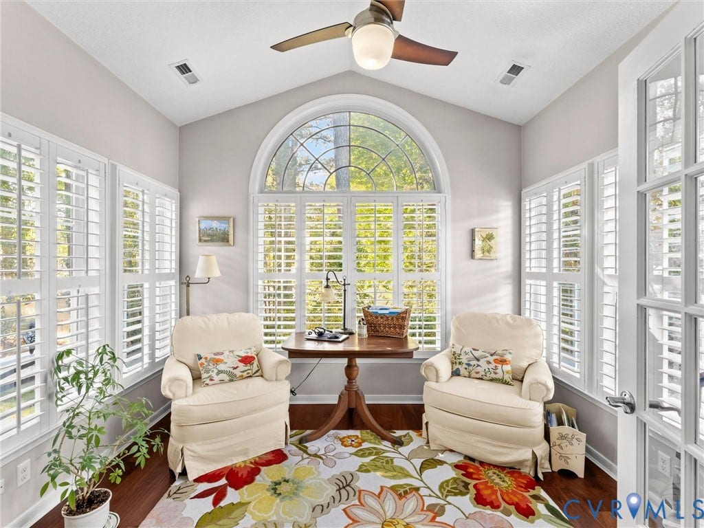 4105 English Holly Circle, Glen Allen, VA 23294 Sunroom featuring a vaulted ceiling, floor-to-ceiling arched window, plantation shutters, wood-finish flooring, and a ceiling fan with integrated lighting