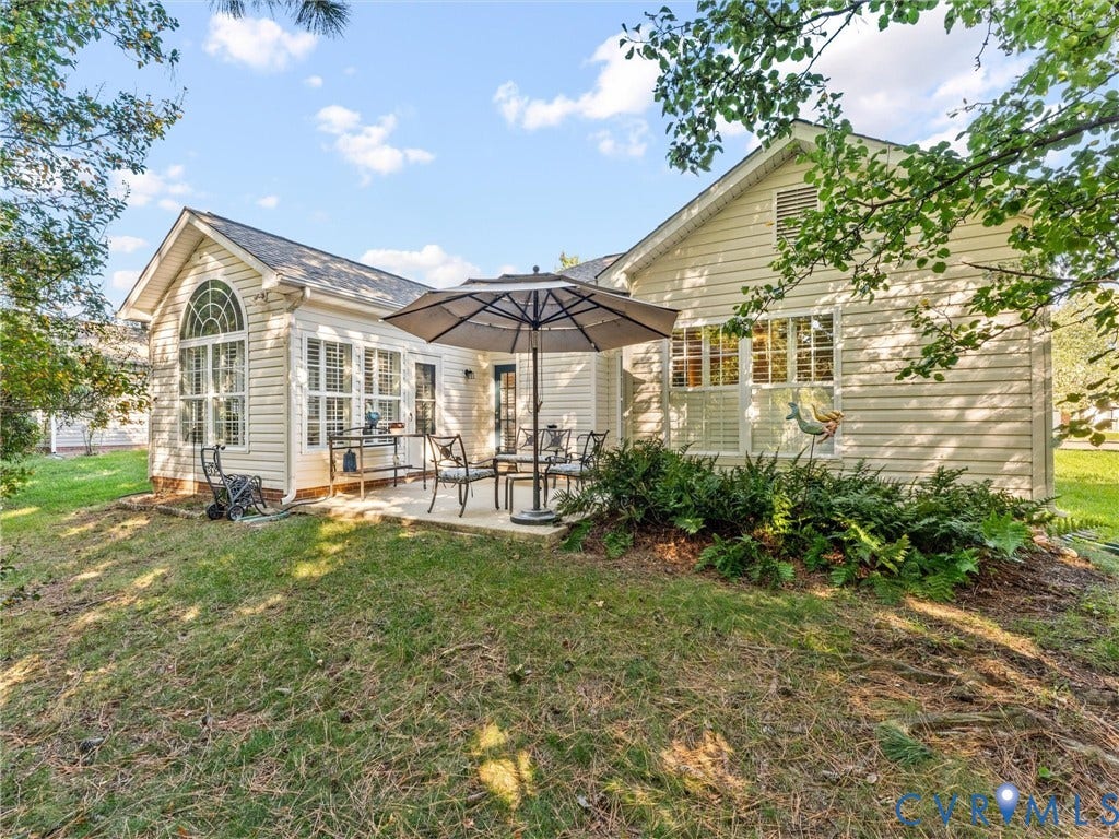 4105 English Holly Circle, Glen Allen, VA 23294 Exterior view featuring light-colored horizontal siding, arched window detailing, concrete patio, and mature landscaping