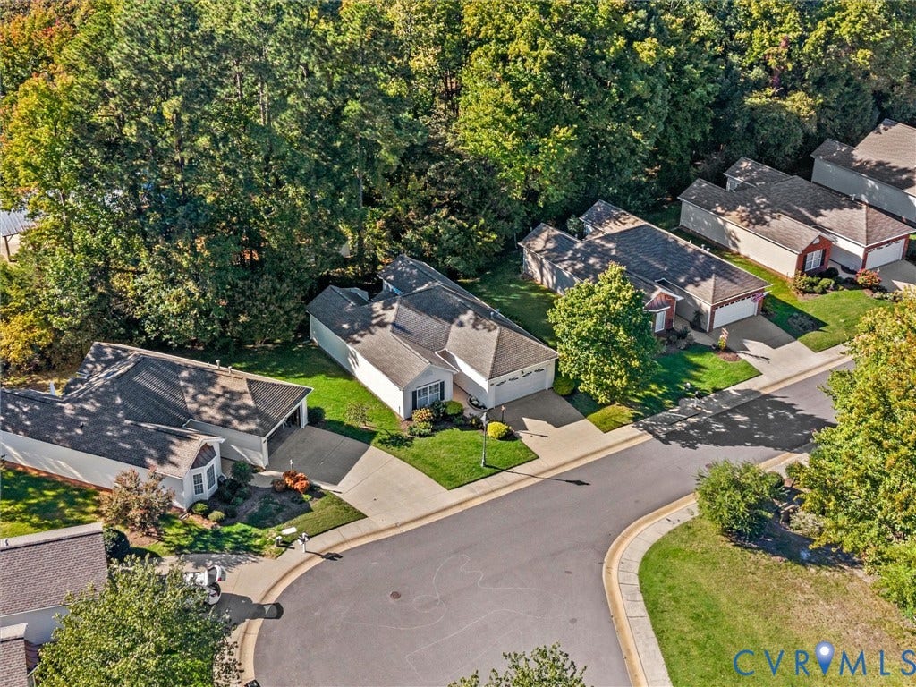 4105 English Holly Circle, Glen Allen, VA 23294 Aerial perspective of a single-story residence featuring a shingled roof, attached two-car garage, concrete driveway, and mature perimeter trees