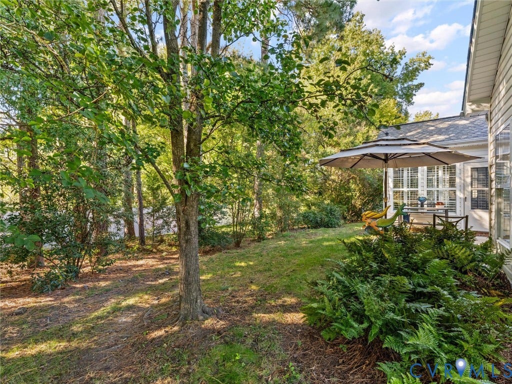 4105 English Holly Circle, Glen Allen, VA 23294 Private backyard featuring mature trees, landscaped shrubbery, grass lawn, and siding exterior