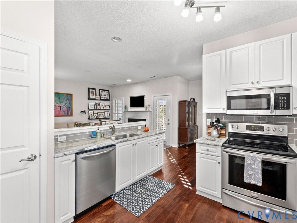 4105 English Holly Circle, Glen Allen, VA 23294 Kitchen featuring white cabinetry, stone-surface countertops, subway tile backsplash, stainless steel appliances, and wood-finish flooring