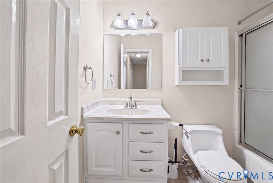 1415 Sycamore Mews Circle, Sycamore Mews, Midlothian, VA 23113 Bathroom featuring a white vanity cabinet with stone-look countertop, integrated sink, three-light fixture, wall-mounted storage cabinetry, and a shower enclosure