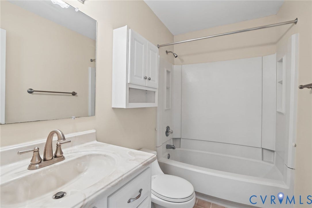 1415 Sycamore Mews Circle, Sycamore Mews, Midlothian, VA 23113 Bathroom featuring a white vanity with integrated sink, stone-composite countertop, wall-mounted storage cabinet, and a shower-tub combination with integrated shelving