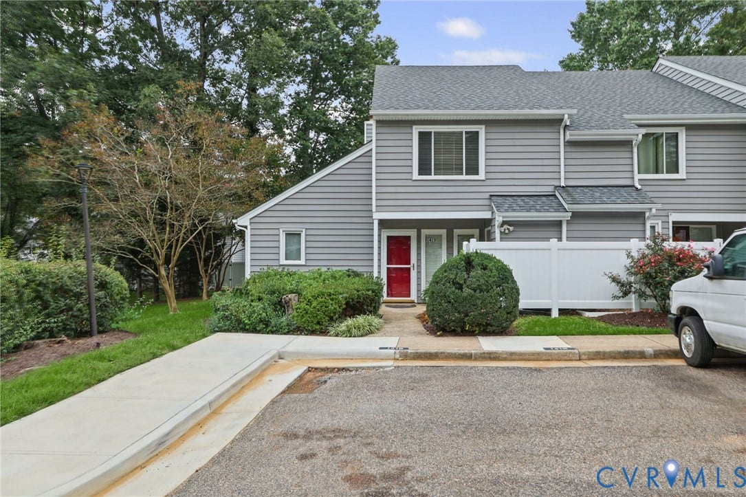 1415 Sycamore Mews Circle, Sycamore Mews, Midlothian, VA 23113 Grey horizontal siding exterior featuring a multi-gable roofline, a red front door, white privacy fencing, and concrete walkway