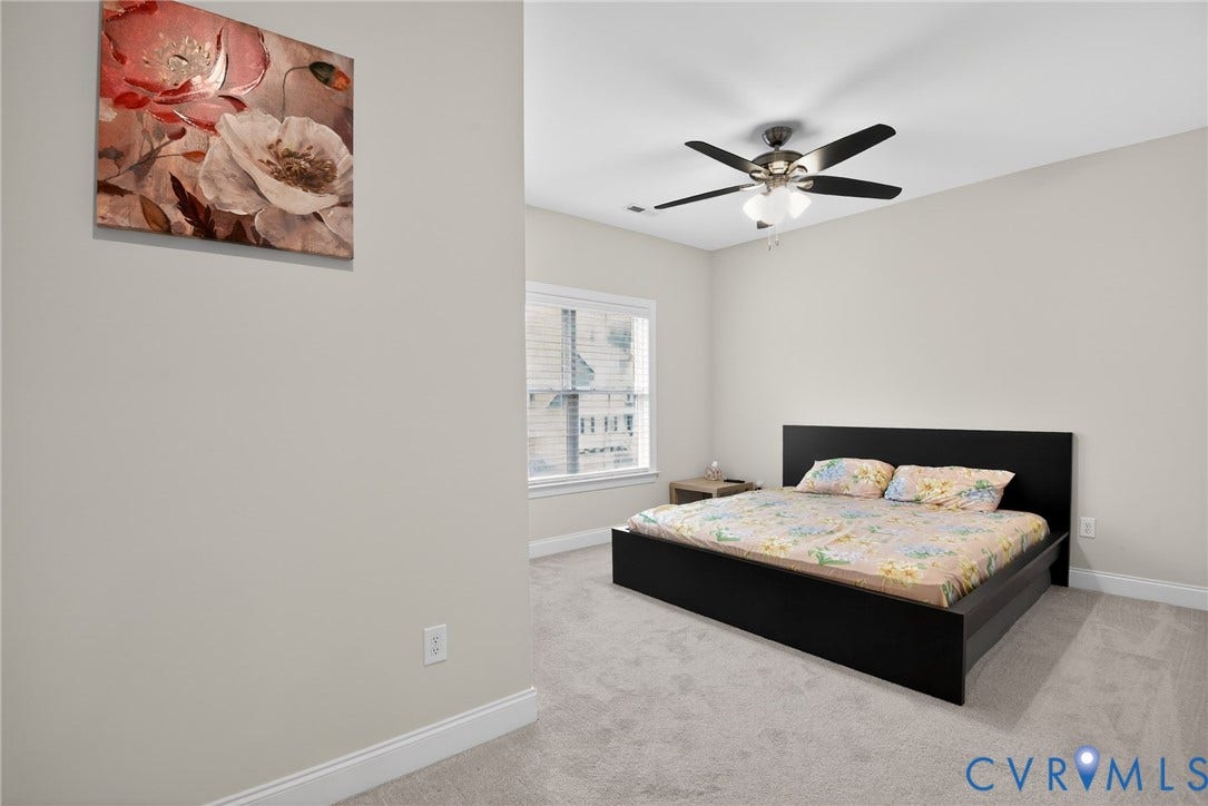 Glen Allen, VA 23059 Neutral-toned interior room featuring wall-to-wall carpeting, a multi-blade ceiling fan with integrated lighting, and a window with white casing