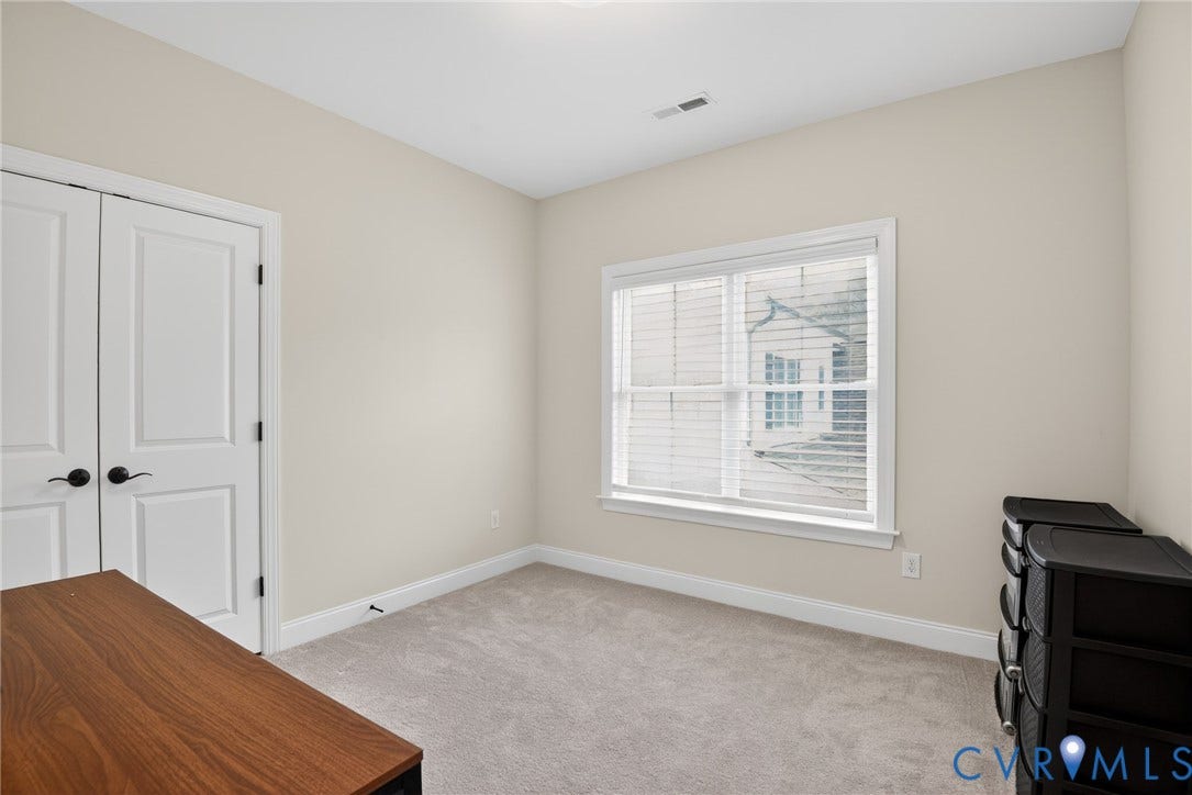 Glen Allen, VA 23059 Neutral interior featuring wall-to-wall carpeting, dual-panel closet doors with matte black hardware, and a window with white casing