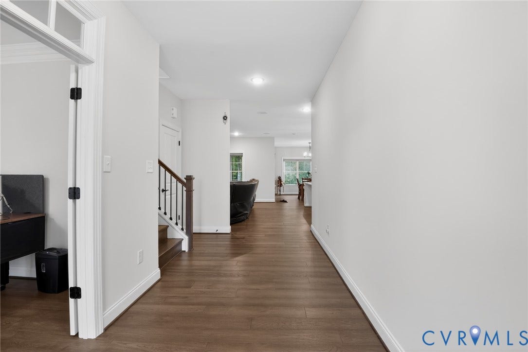 Glen Allen, VA 23059 Interior hallway featuring wood-finish flooring, recessed lighting, and a staircase with a dark-stained wood handrail and square balusters