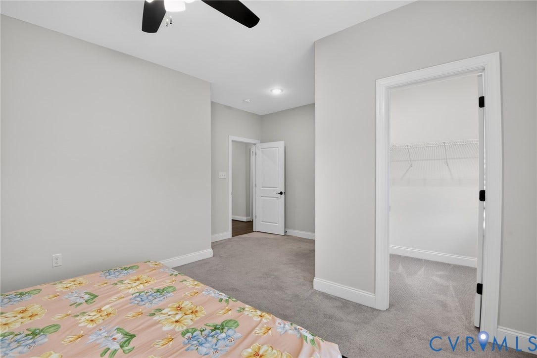 Glen Allen, VA 23059 Room featuring wall-to-wall carpeting, ceiling fan with integrated lighting, neutral wall paint, and walk-in closet with built-in wire shelving
