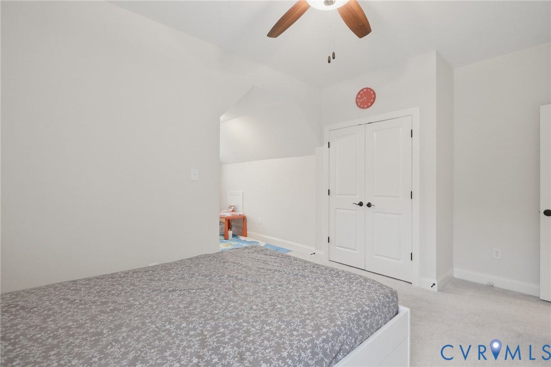 Glen Allen, VA 23059 Room featuring neutral wall tones, carpeted flooring, a ceiling fan, and double-door closet storage with black hardware