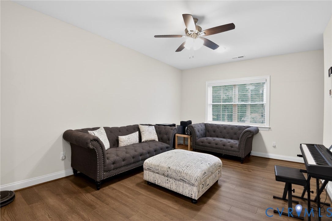 Glen Allen, VA 23059 Wood-finish flooring, neutral wall tones, multi-pane window, and a central ceiling fan with integrated lighting
