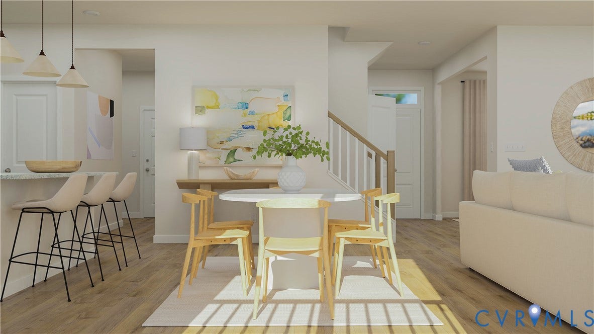 17313 Gossamer Drive, Chesterfield, VA 23120 Open-concept space featuring wood-finish flooring, a kitchen peninsula with bar seating, pendant lighting, and a staircase with a wooden handrail and balusters