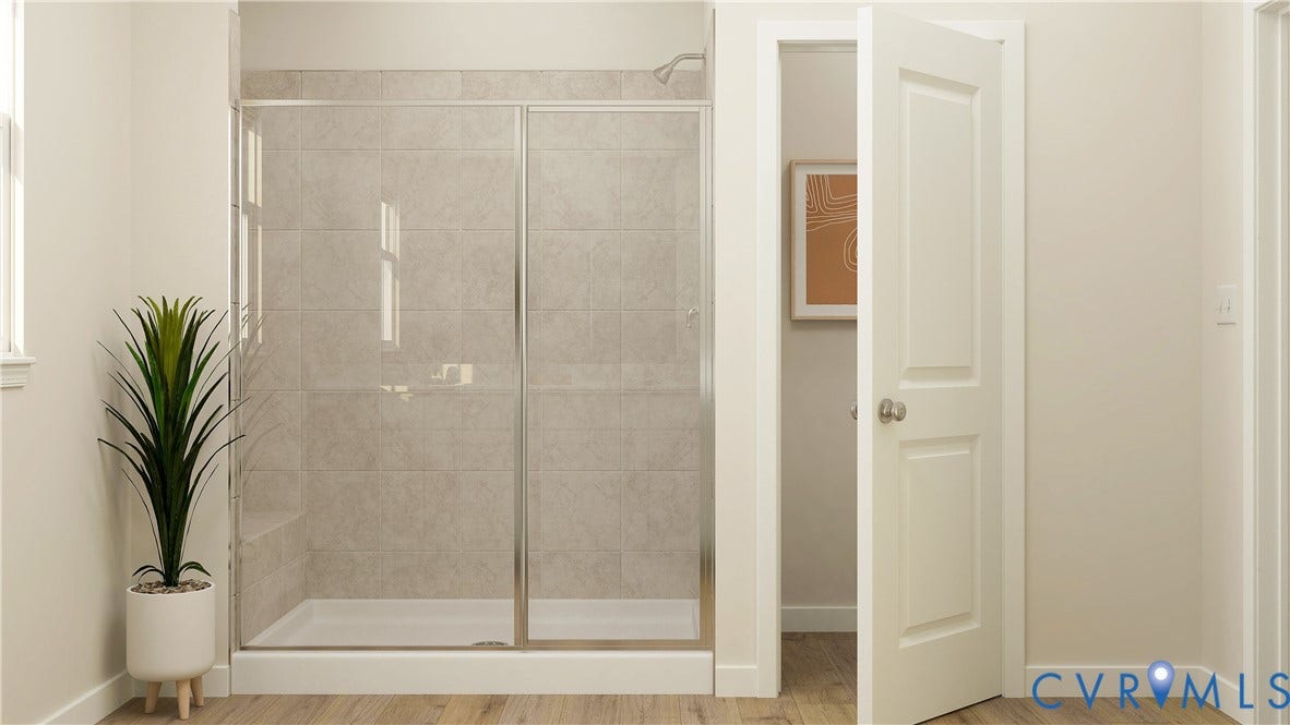 17313 Gossamer Drive, Chesterfield, VA 23120 Walk-in shower featuring light-toned tile surround, glass enclosure with metallic trim, and wood-finish flooring