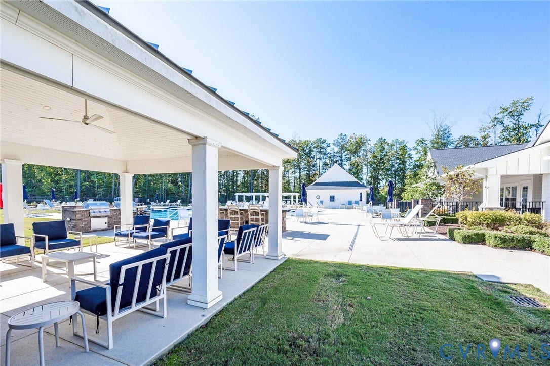 7577 Southamptonshire Way, Autum Pines, New Kent, VA 23124 Covered outdoor pavilion featuring a vaulted beadboard ceiling, recessed lighting, and a ceiling fan, spanning a concrete patio area with a built-in stone-finished outdoor kitchen