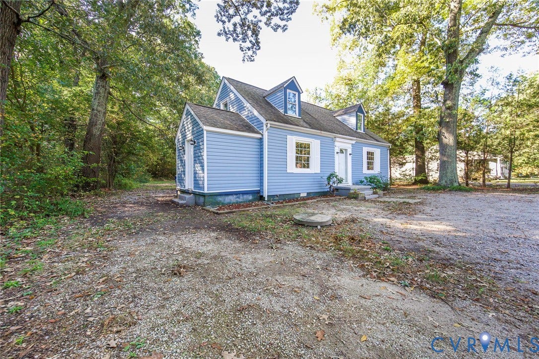 3017 Kingsdale Road, Chesterfield, VA 23237 Cape Cod style residence featuring blue horizontal siding, two roof dormers, white shutters, and a gravel driveway