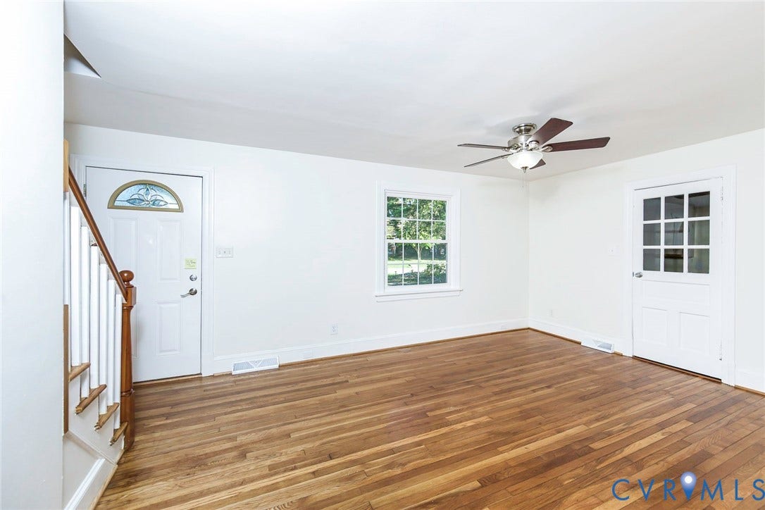 3017 Kingsdale Road, Chesterfield, VA 23237 Interior space featuring wood-finish flooring, a multi-lite exterior door, a front door with a decorative transom window, a central ceiling fan with integrated light fixture, and a wooden staircase railing