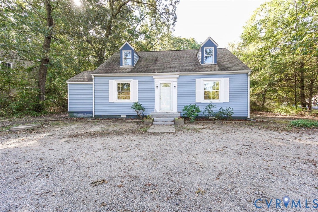 3017 Kingsdale Road, Chesterfield, VA 23237 Cape Cod-style residence featuring light blue siding, dual roof dormers, white louvered shutters, and a gravel driveway