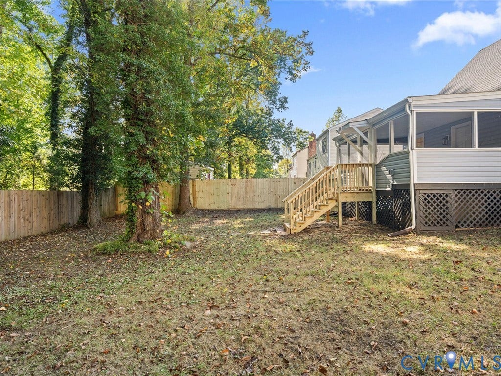 5105 Carryback Drive, Richmond, VA 23234 Rear yard featuring a screened-in porch with wood stairs, a full-height wood perimeter fence, and mature trees