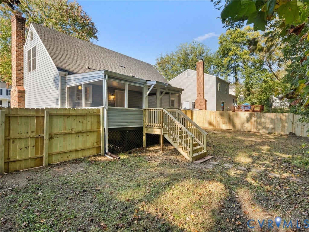 5105 Carryback Drive, Richmond, VA 23234 Exterior view featuring light-toned horizontal siding, a screened-in porch, a wooden deck with stairs, a brick chimney, and a wooden privacy fence