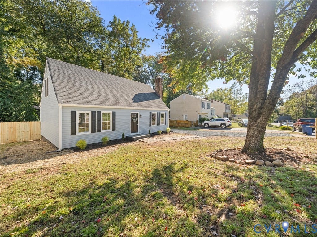5105 Carryback Drive, Richmond, VA 23234 Charming cottage-style home featuring a gabled roof with architectural shingles, blue entry door with sidelights, and multiple windows with dark trim