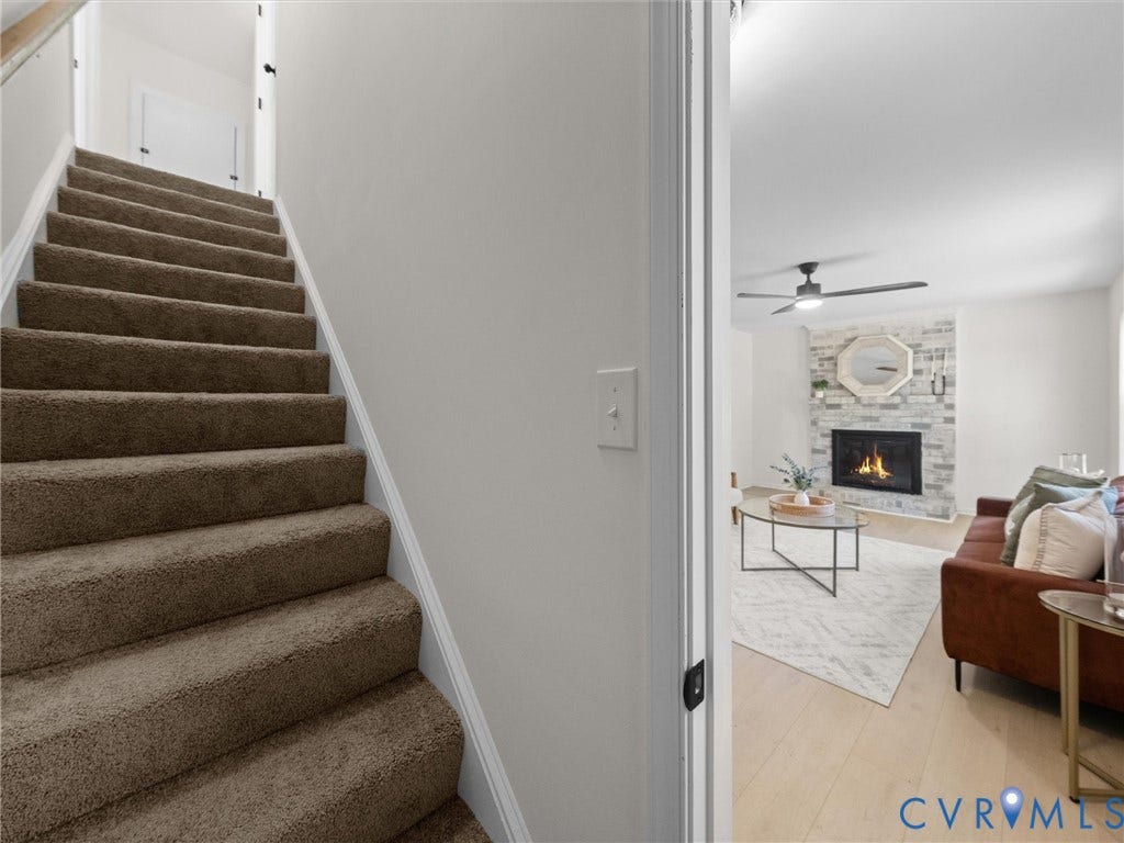 5105 Carryback Drive, Richmond, VA 23234 Carpeted staircase with a wood-finish handrail, wood-finish flooring, stone-veneer fireplace surround, and a ceiling-mounted fan