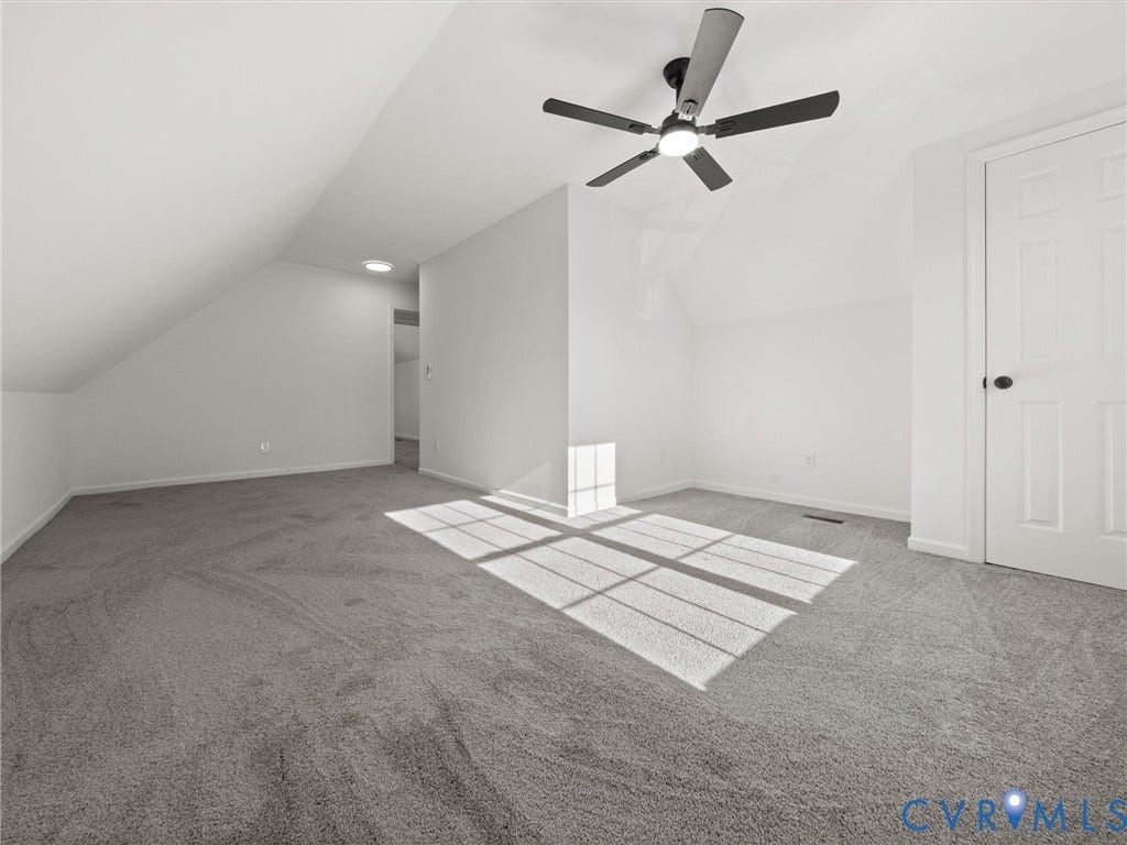 5105 Carryback Drive, Richmond, VA 23234 Neutral-toned carpeting, vaulted ceiling with architectural pitch, four-blade ceiling fan with integrated lighting, and a paneled interior door