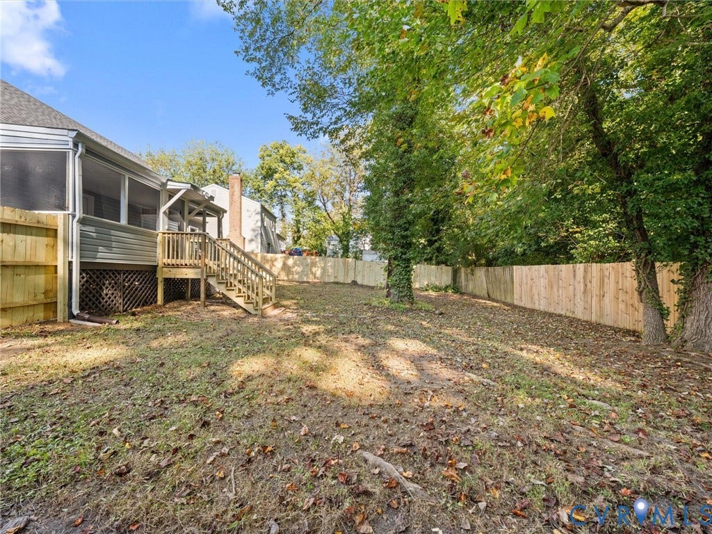 5105 Carryback Drive, Richmond, VA 23234 Backyard featuring a screened-in porch, wood stairs with railings, lattice skirting, and a perimeter wood privacy fence