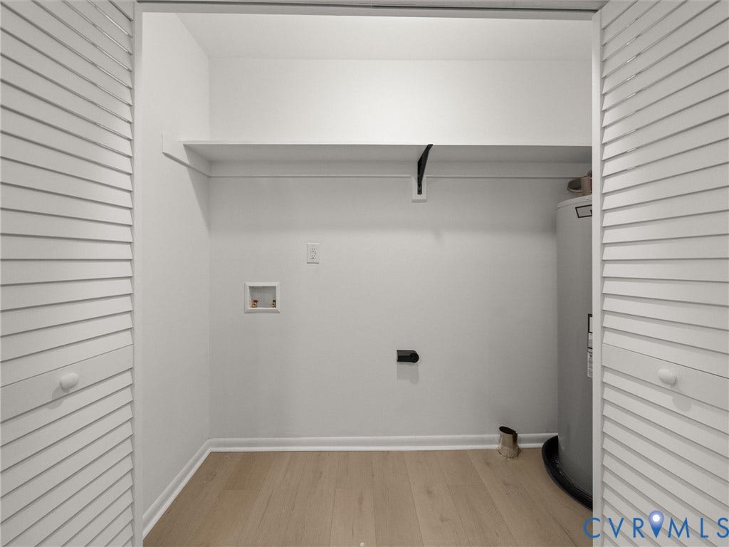 5105 Carryback Drive, Richmond, VA 23234 Utility closet featuring louvered bi-fold doors, wood-finish flooring, built-in shelving, and dedicated water heater enclosure