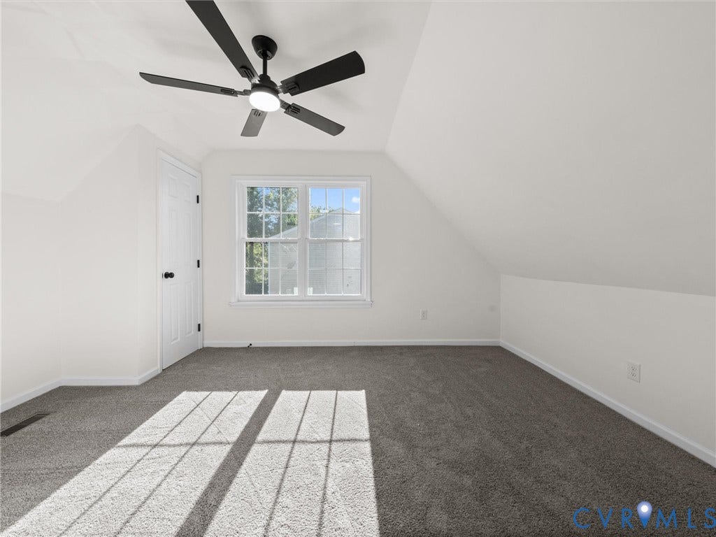 5105 Carryback Drive, Richmond, VA 23234 Room featuring vaulted ceilings, neutral carpeting, a multi-pane window, and a matte black ceiling fan with integrated lighting