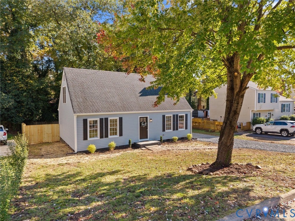 5105 Carryback Drive, Richmond, VA 23234 Cape Cod style exterior featuring light blue siding, dark shutters, an asphalt shingle roof, and a wood privacy fence