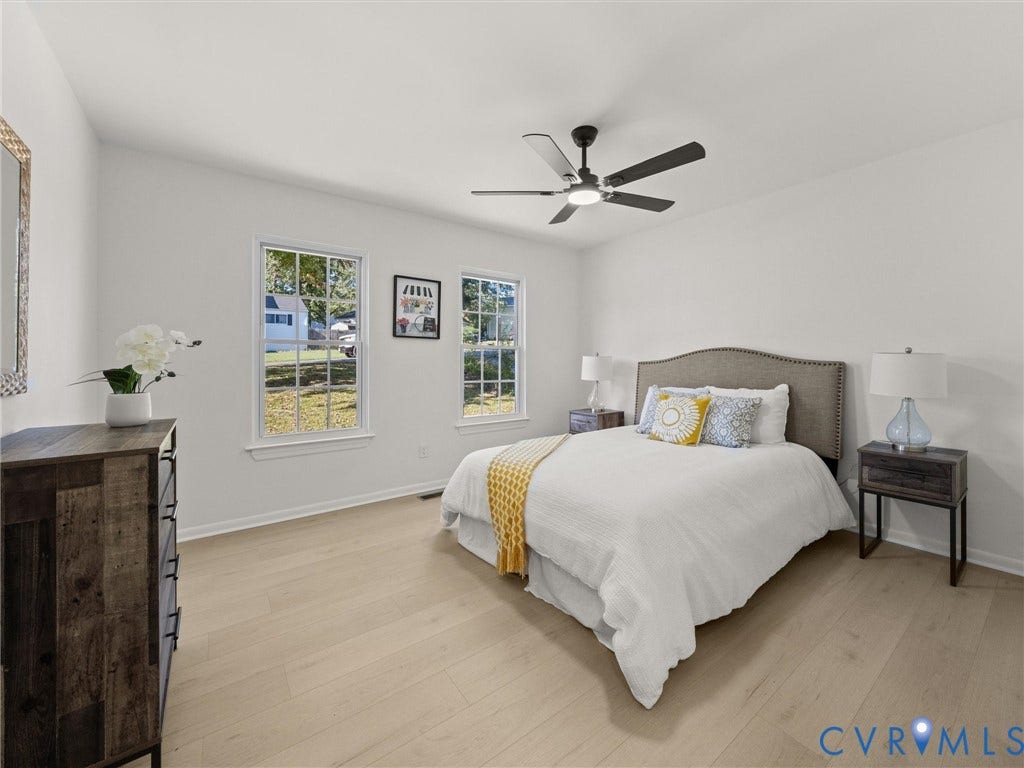 5105 Carryback Drive, Richmond, VA 23234 Neutral-toned room featuring wood-finish flooring, dual windows with grid detailing, and a modern ceiling fan with integrated lighting