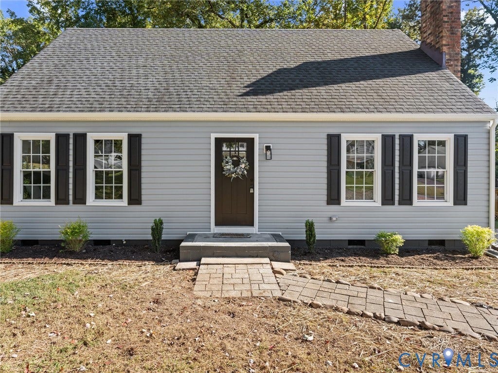 5105 Carryback Drive, Richmond, VA 23234 Exterior featuring light gray horizontal siding, dark shutters, a stone-finished walkway, a multi-pane front door, and a brick chimney