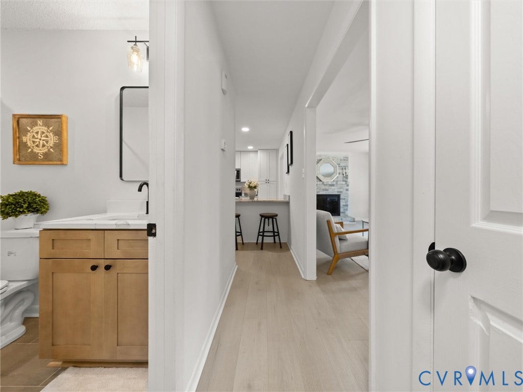 5105 Carryback Drive, Richmond, VA 23234 Bathroom vanity featuring a light-toned wood finish cabinet, rectangular countertop, and matte black faucet