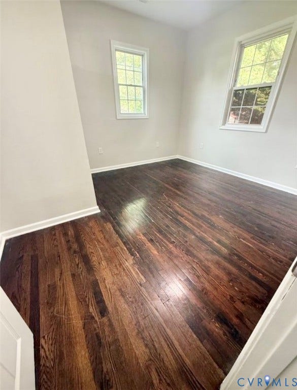 1201 W Broadway, Hopewell, VA 23860 Dark-toned wood-finish flooring, neutral wall paint, and two double-hung windows with mullions