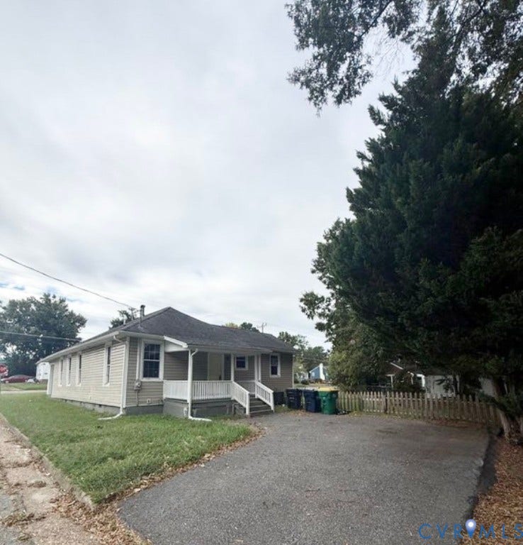 1201 W Broadway, Hopewell, VA 23860 Single-story exterior featuring light-toned horizontal siding, a covered front porch with white railing, and an asphalt driveway