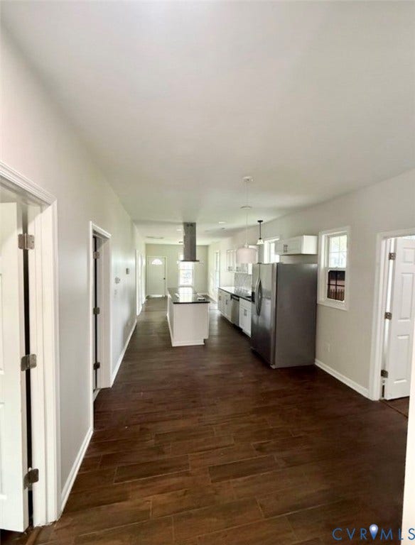 1201 W Broadway, Hopewell, VA 23860 Kitchen featuring wood-finish flooring, white cabinetry, a center island, stainless steel refrigerator, and stainless steel range hood