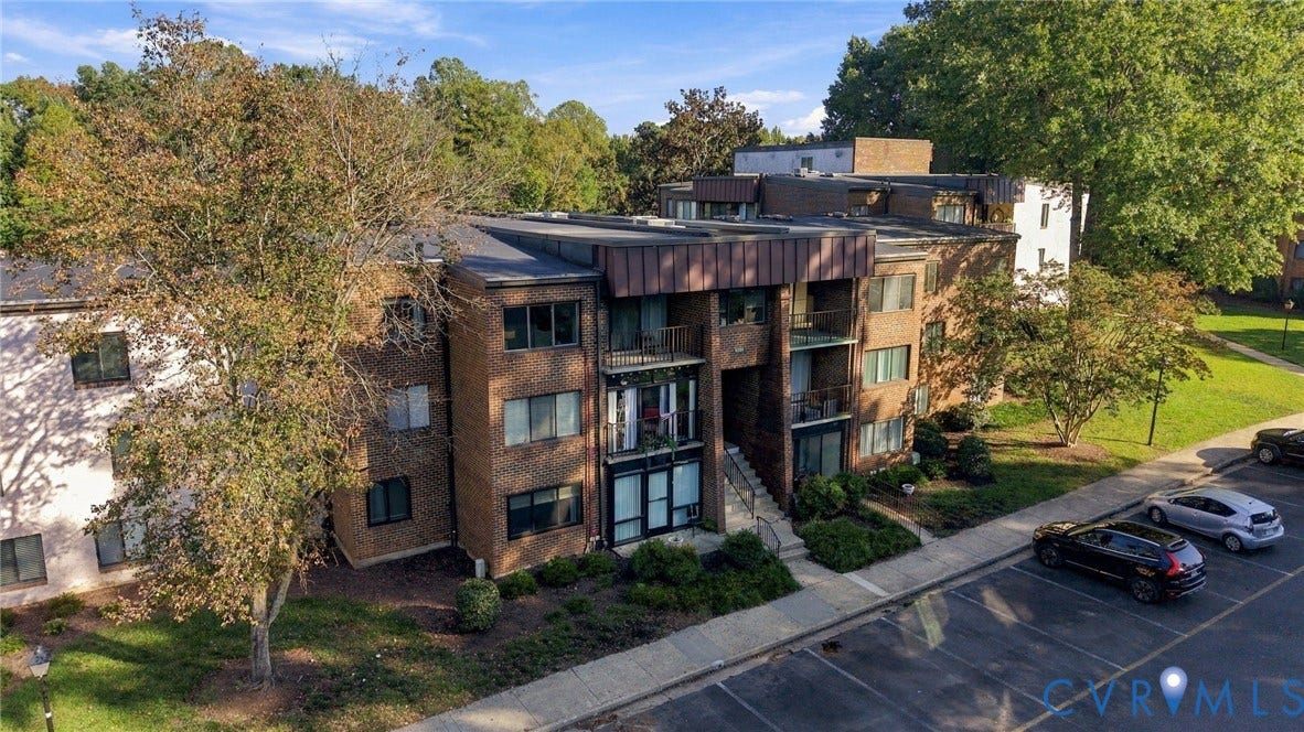 1503 Bronwyn Road, #303, Regency, Henrico, VA 23238 Multi-story brick exterior featuring a flat roofline, metal roof accents, and integrated private balconies