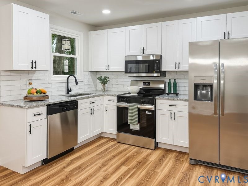 2500 ford Avenue, Richmond, VA 23223 Kitchen featuring white shaker-style cabinetry, stone-finish countertops, subway tile backsplash, stainless steel appliances, and wood-finish flooring