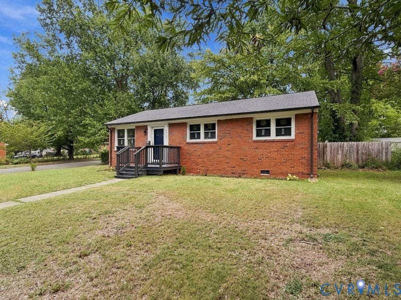 2500 ford Avenue, Richmond, VA 23223 Brick exterior residence featuring a dark-toned wood deck entry, multi-pane windows, and a detached wooden perimeter fence