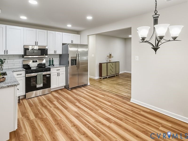 2500 ford Avenue, Richmond, VA 23223 Kitchen featuring white shaker-style cabinetry, stone countertops, white subway tile backsplash, stainless steel appliances, and wood-finish flooring