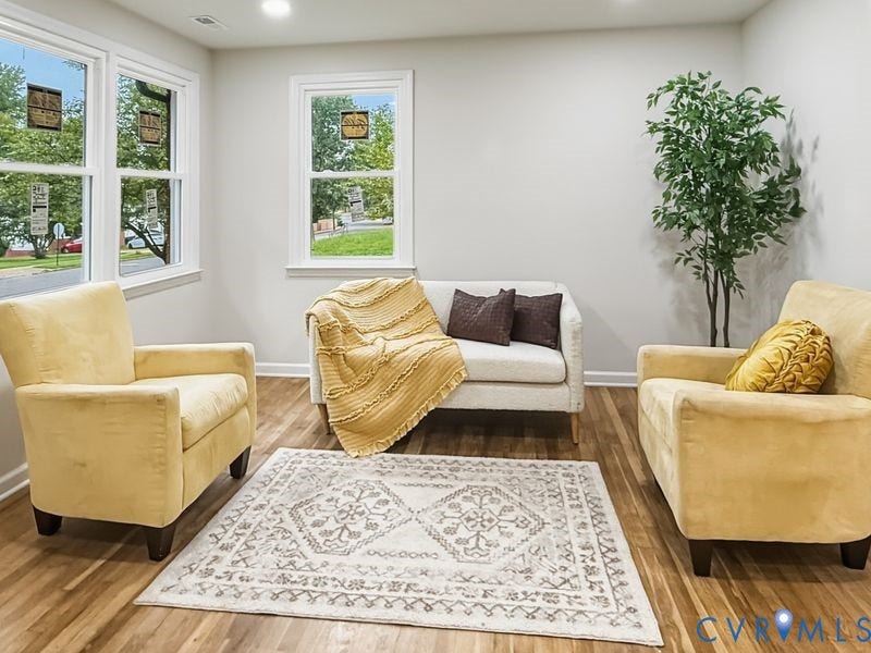 2500 ford Avenue, Richmond, VA 23223 Bright interior featuring wood-finish flooring, neutral wall tones, and three double-hung windows with white trim, complemented by recessed lighting
